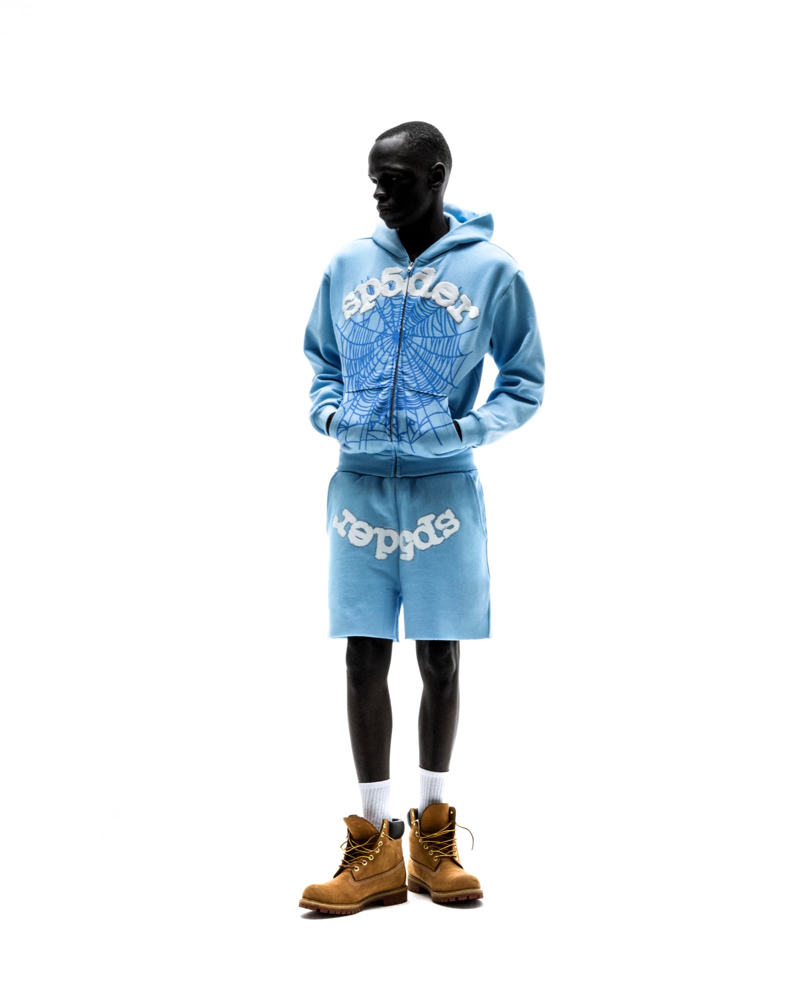 Model in light blue OG WEB ZIP UP hoodie and matching shorts with white spiderweb print.