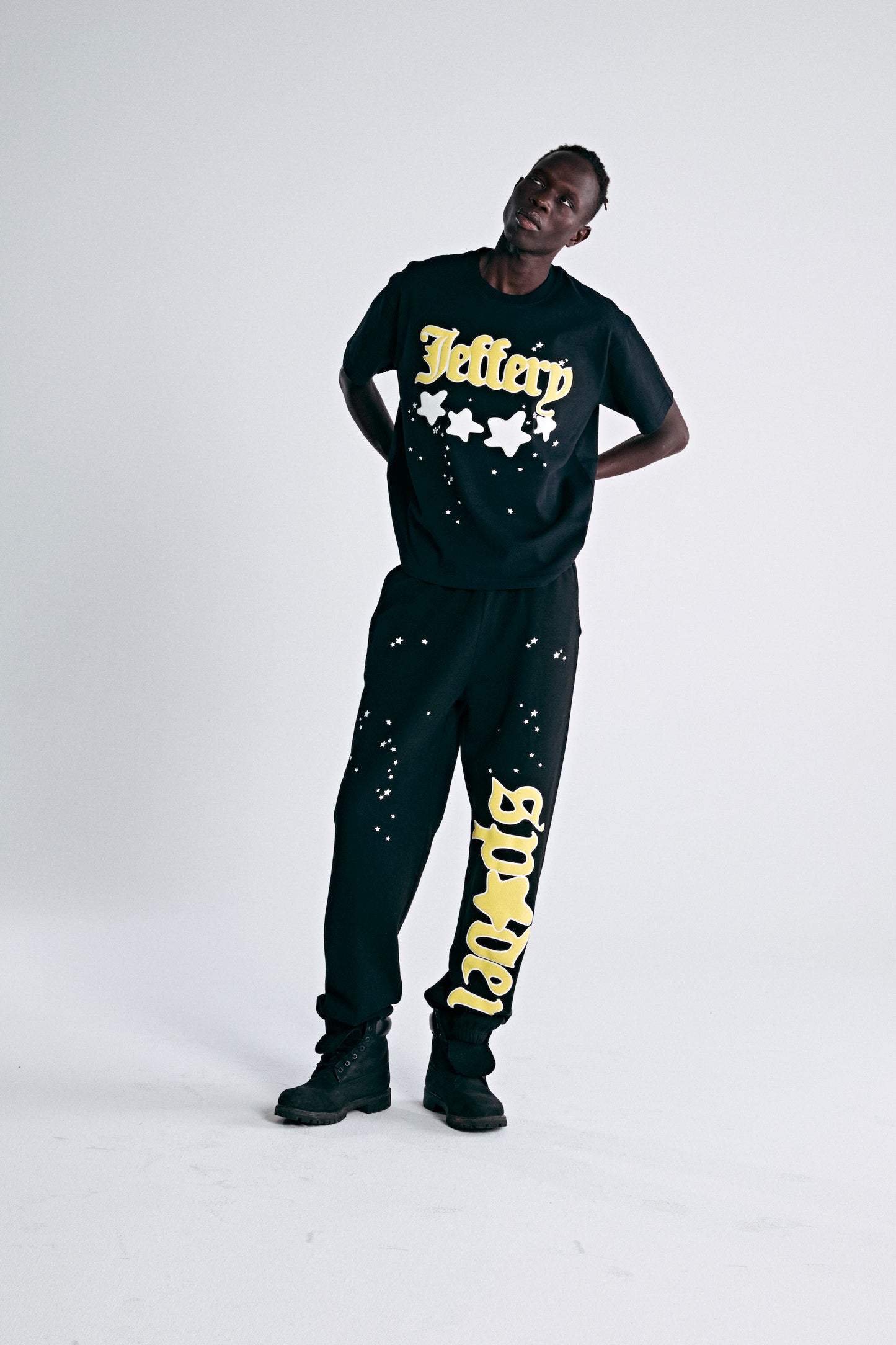 Black heavyweight cotton tee with yellow "Jeffery" puff print and discharge star graphics.