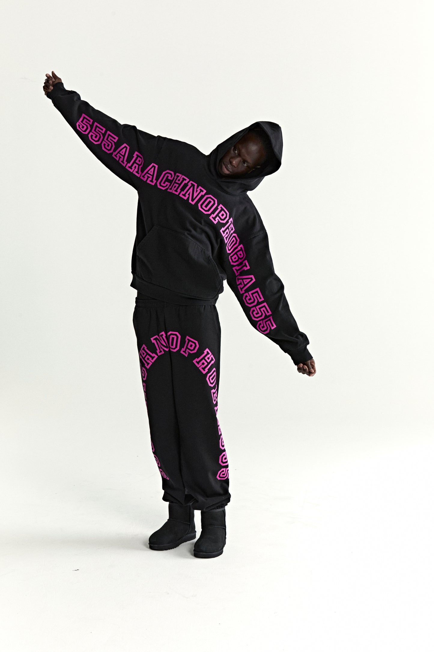 Black 13oz cotton fleece ARACH HOODIE with pink puff print text on chest and arms, kangaroo pocket.