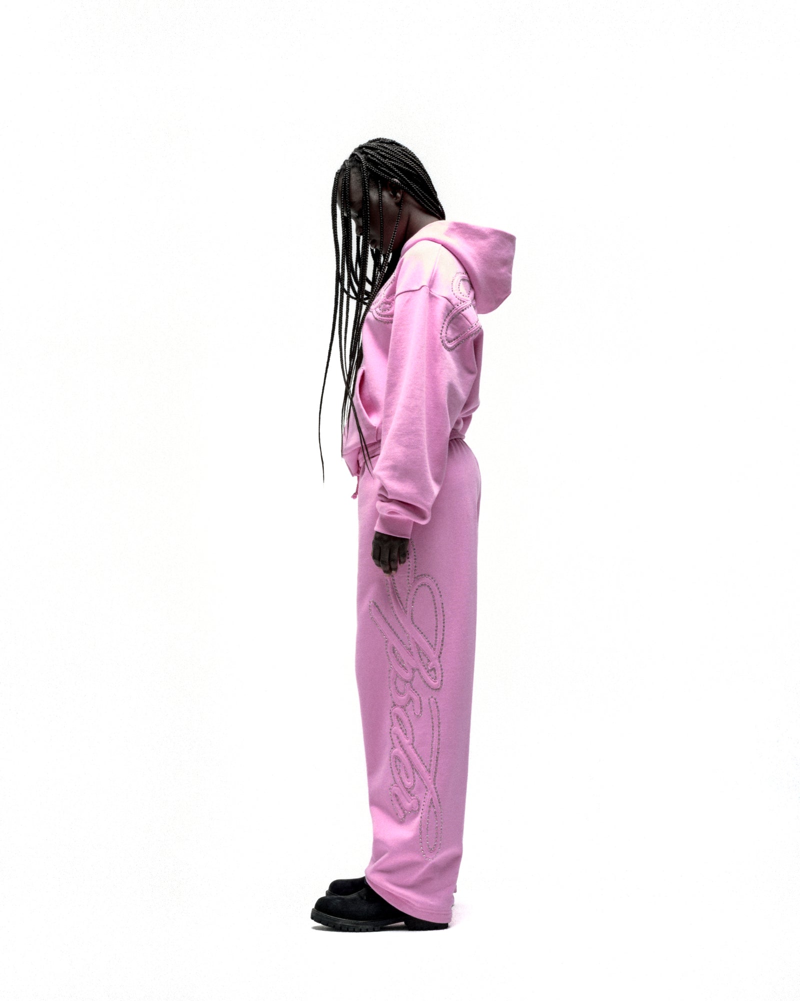 Pink rhinestone script zip hoodie and matching sweatpants on a model.