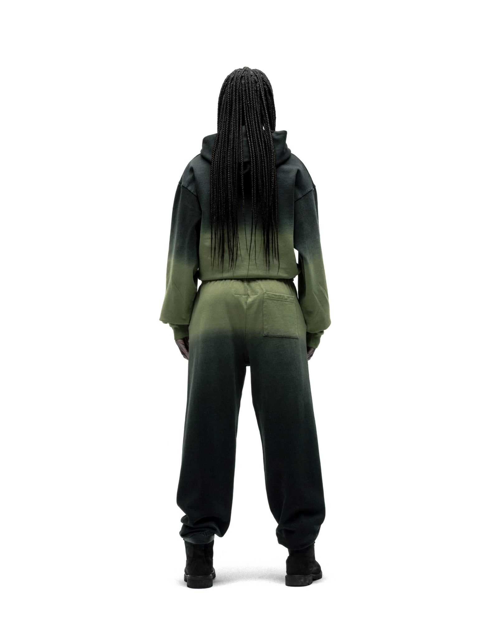 Model from behind wearing an OG WEB OMBRE SWEATPANT set with a dark green to light green ombre design.