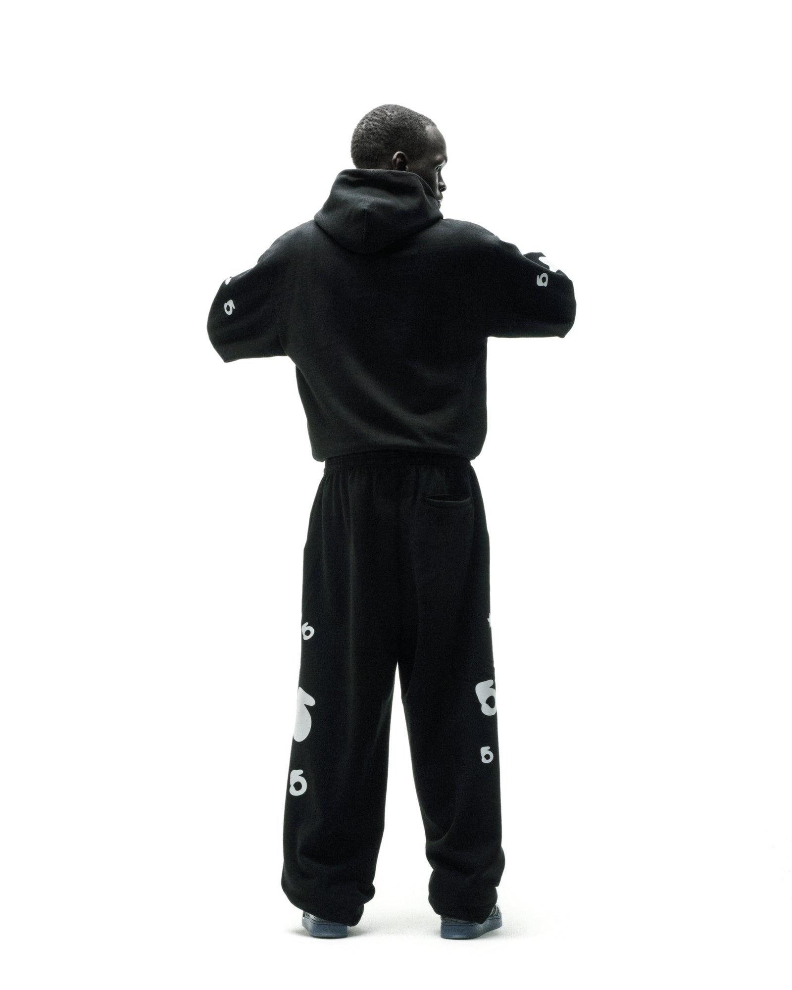 Black cotton fleece hoodie and sweatpants with reflective 'SP5DER' and star print.