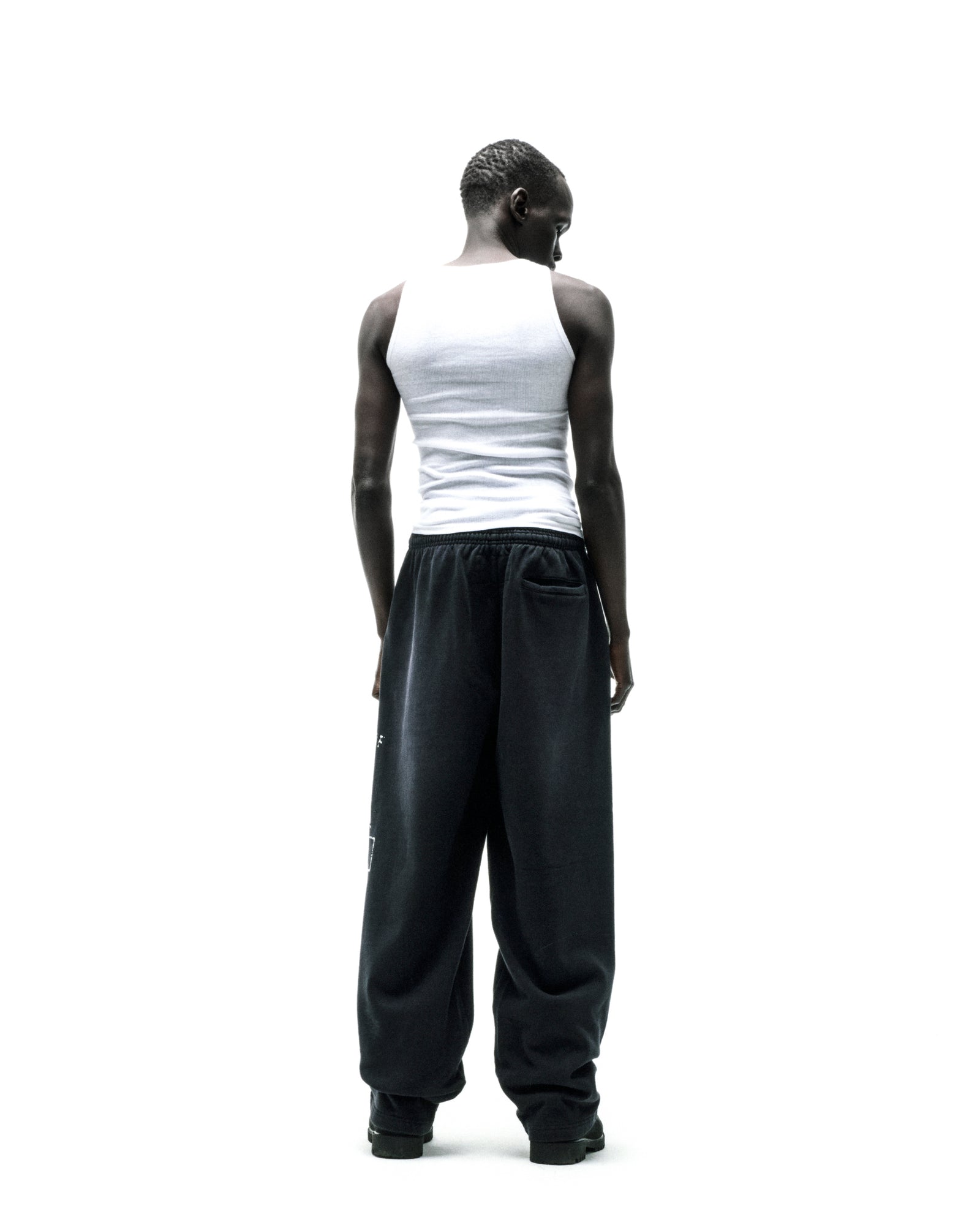 Black wide-leg fleece sweatpants with faded graphic print and raised chenille lettering.