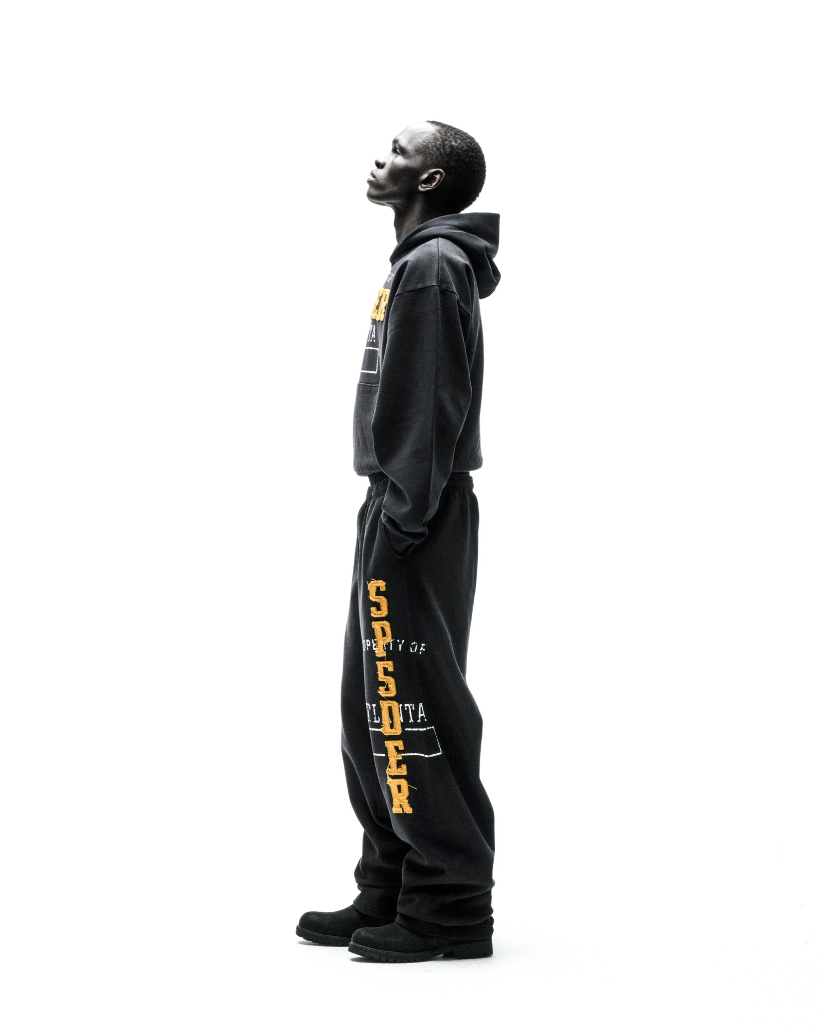 Black cotton fleece hoodie and sweatpants with raised chenille-style "SPSDER" lettering and frayed edges.