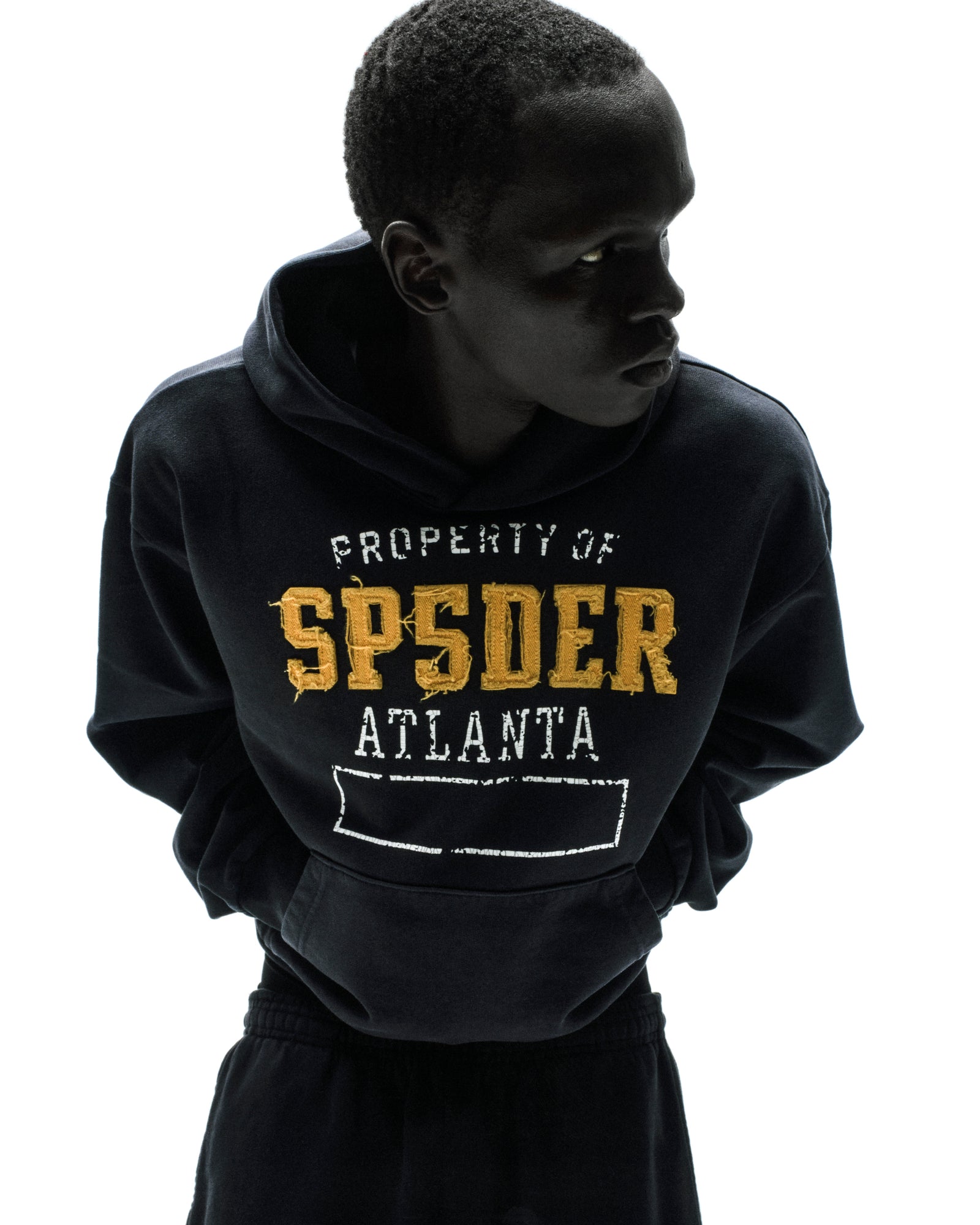 Black cotton fleece hoodie with raised, frayed gold "SPSDER" lettering and "PROPERTY OF ATLANTA" text.