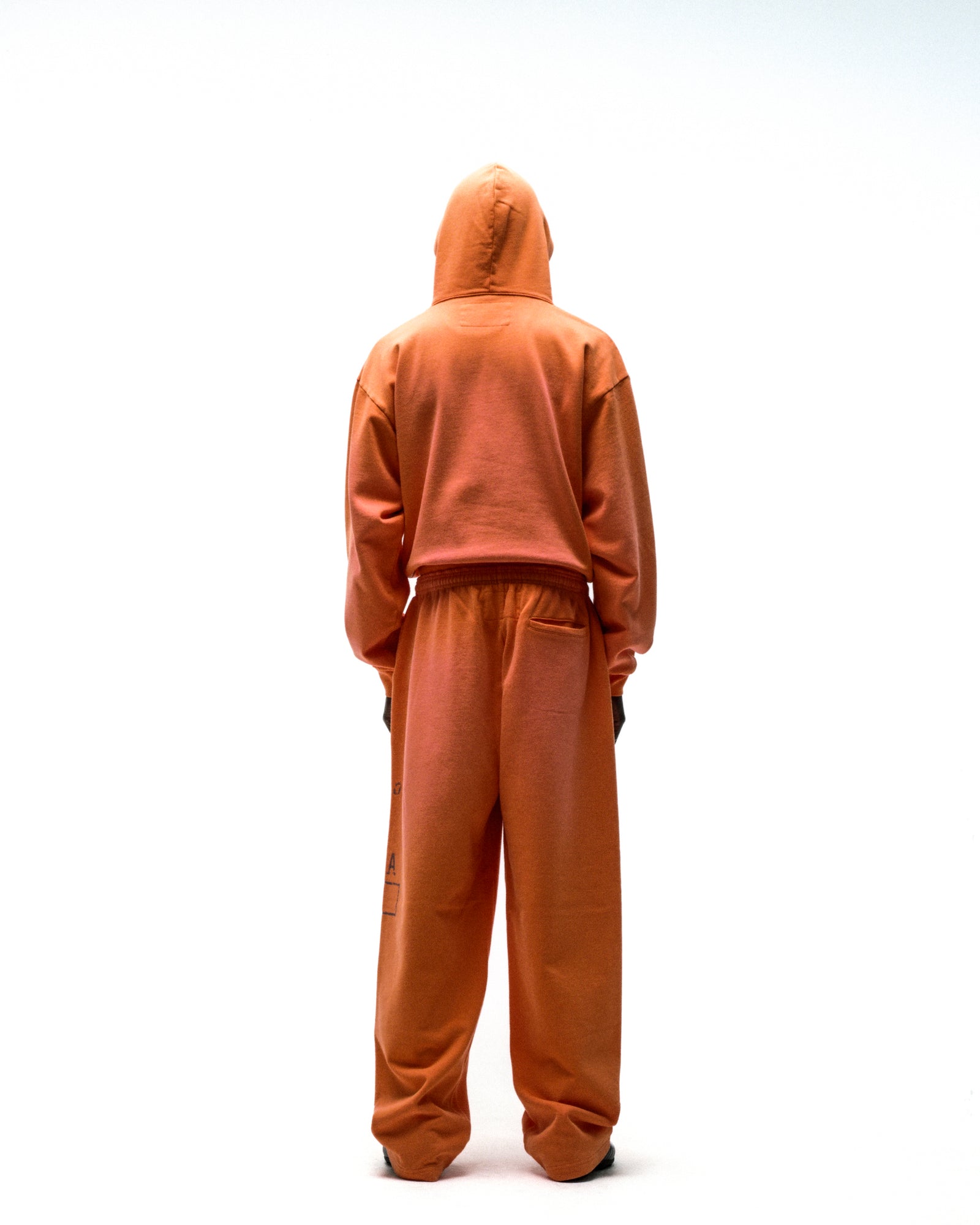 Orange cotton fleece hoodie and sweatpants set, seen from behind.