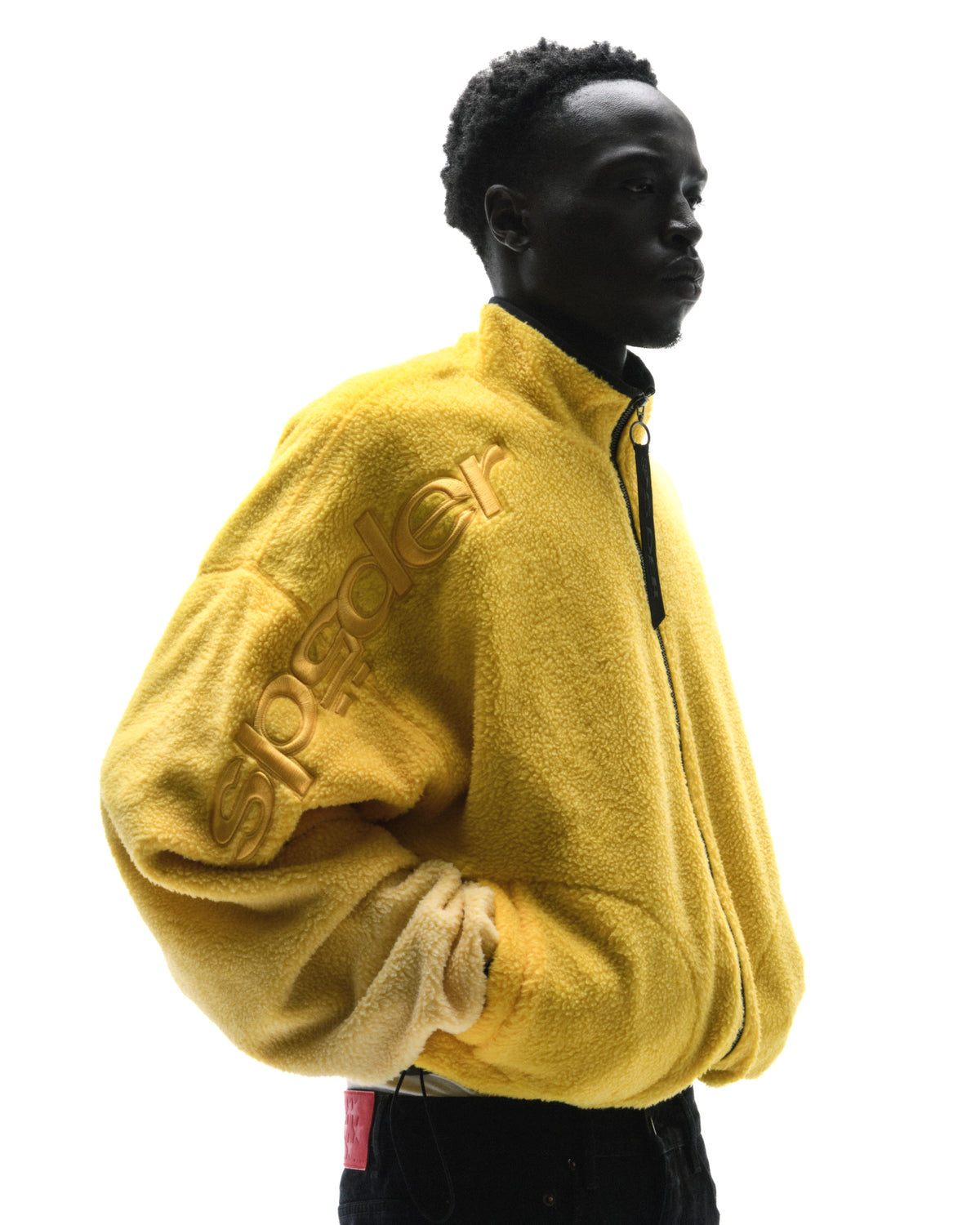Model wearing a bright yellow, textured fleece zip-up jacket with an embossed Spyder logo against a white background.