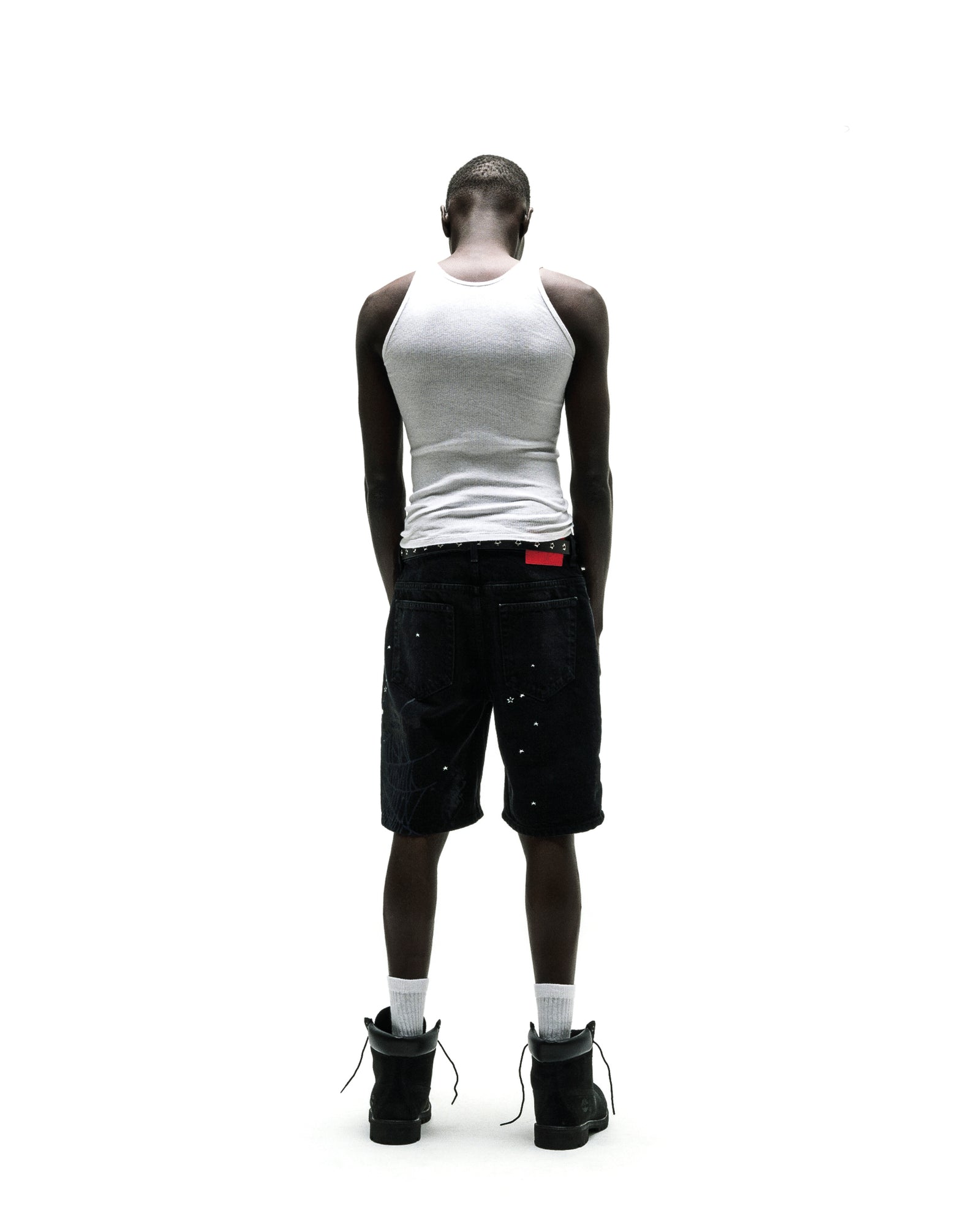 Black denim Heavy Web Jean Short with silver studs, red tag, and black boots.