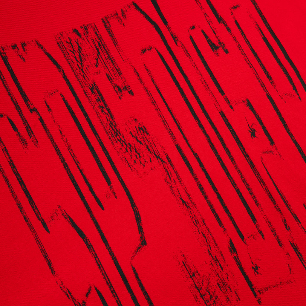 Red 100% cotton tee with a black diffused collegiate graphic print.