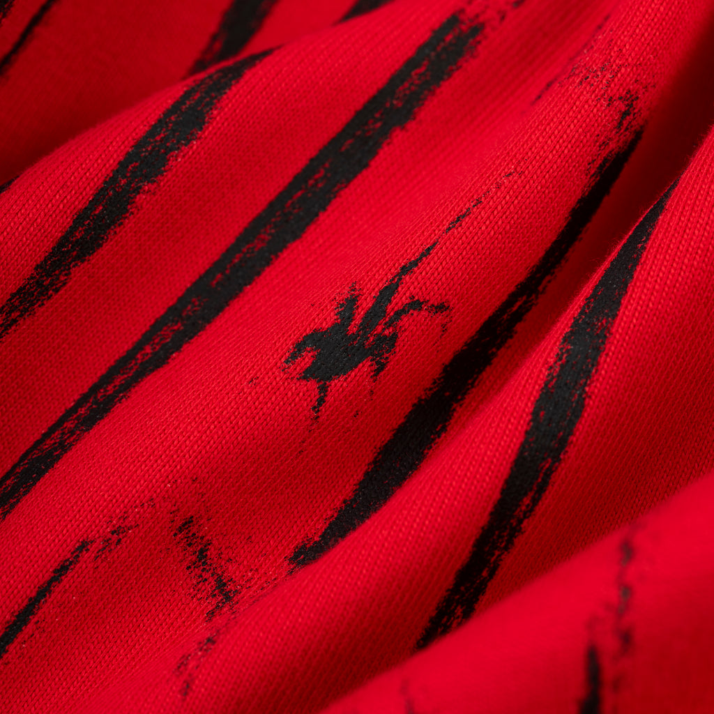Red 100% cotton tee with black distressed stripe graphic and small black spider logo.