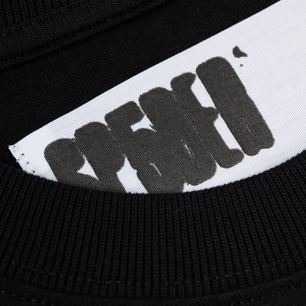 Close-up of black cotton tee with white 'SP5DER' logo on back neck.