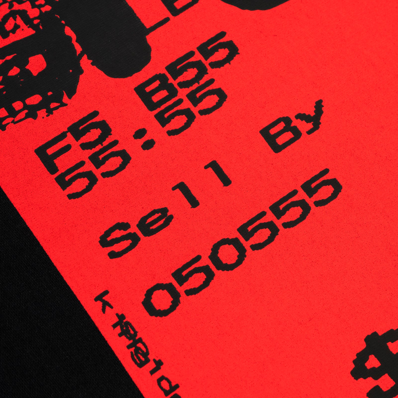 Close-up of a black 'TOAST TEE' with a bold red graphic print featuring black text and numbers.