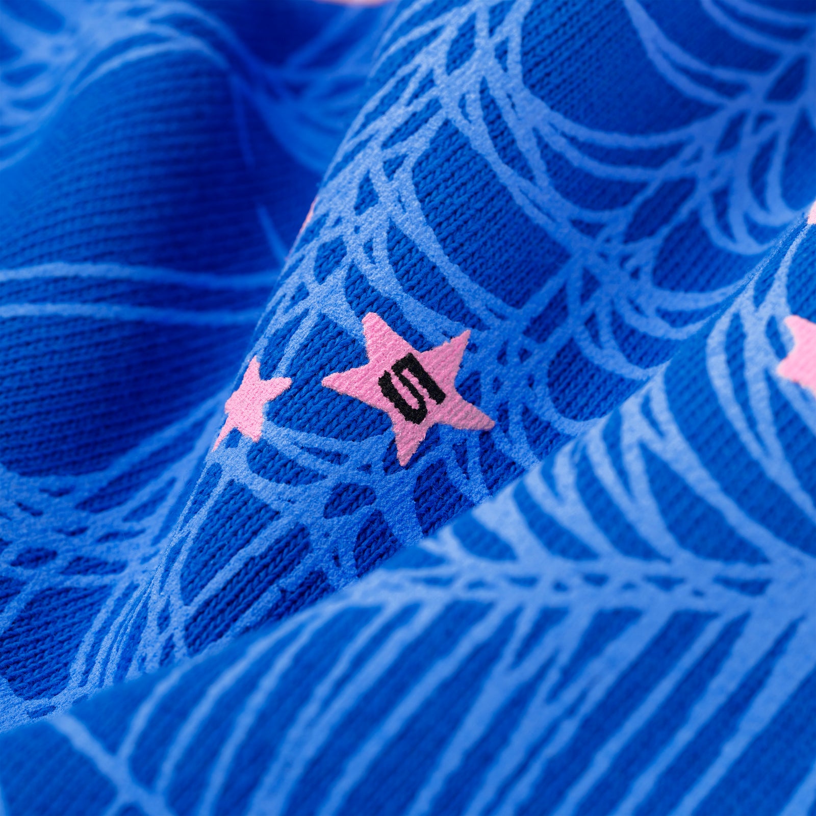 Blue ANGEL NUMBER HOODIE fabric with pink stars, '555' angel numbers, and web print.