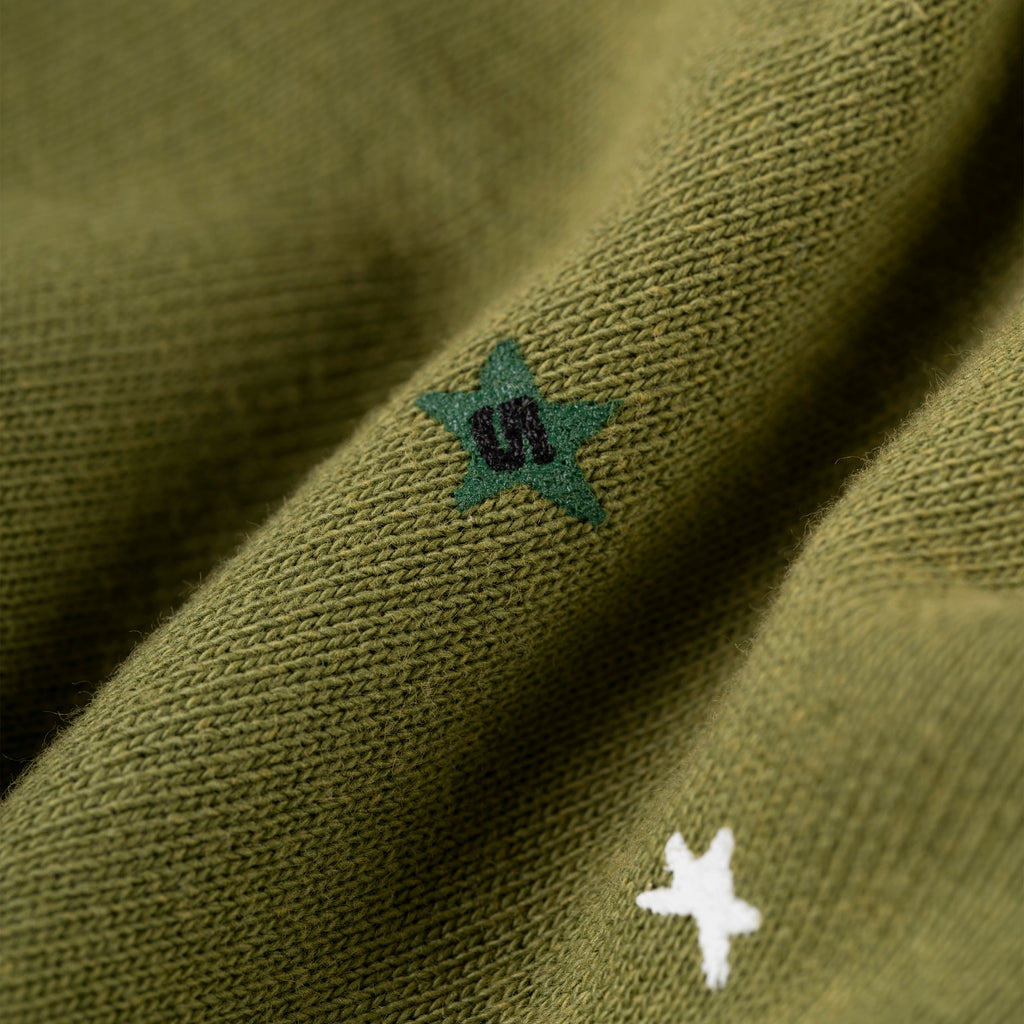 Olive green heavy web sweatpants with scattered white and green star prints.