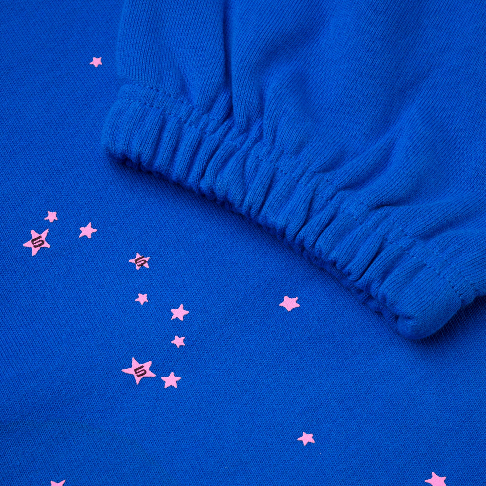 Blue cotton fleece sweatpant with pink scattered stars and elasticized cuff.