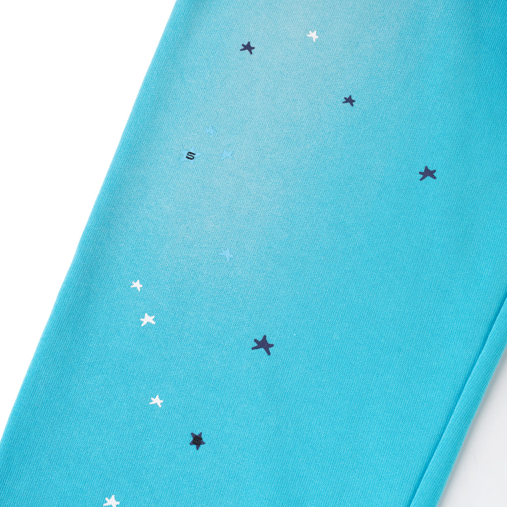Teal cotton fleece sweatpants with scattered white and dark blue star print, and a small "S" graphic.