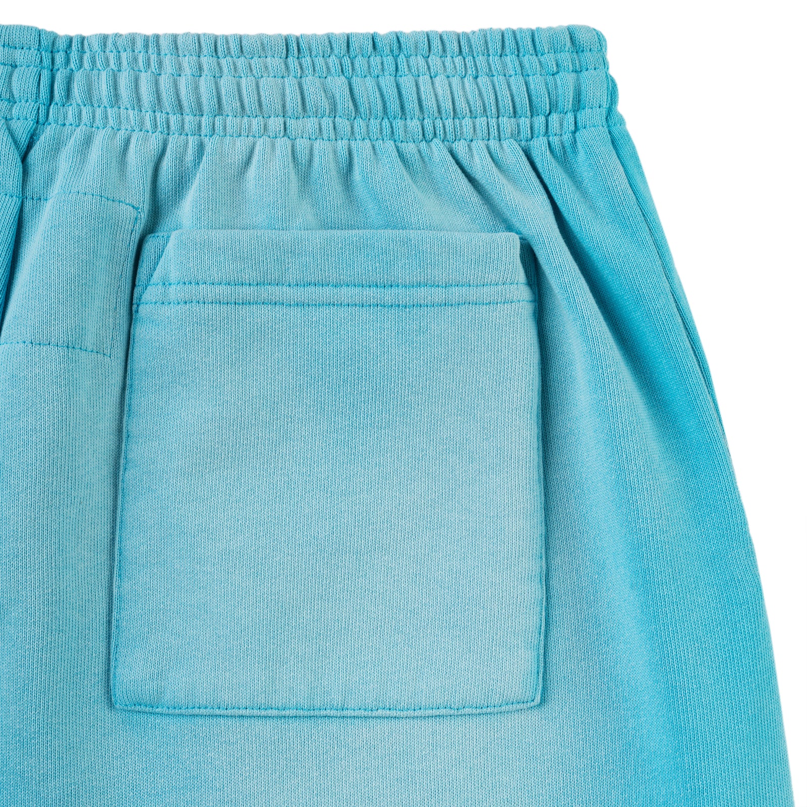 Close-up of a light blue cotton fleece sweatpant with an elasticized waistband and a back patch pocket.