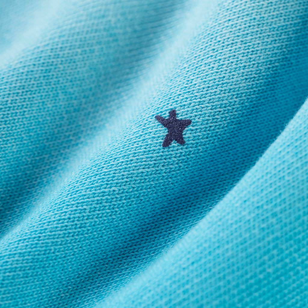 Close-up of blue cotton fleece sweatpant with a small dark star print.