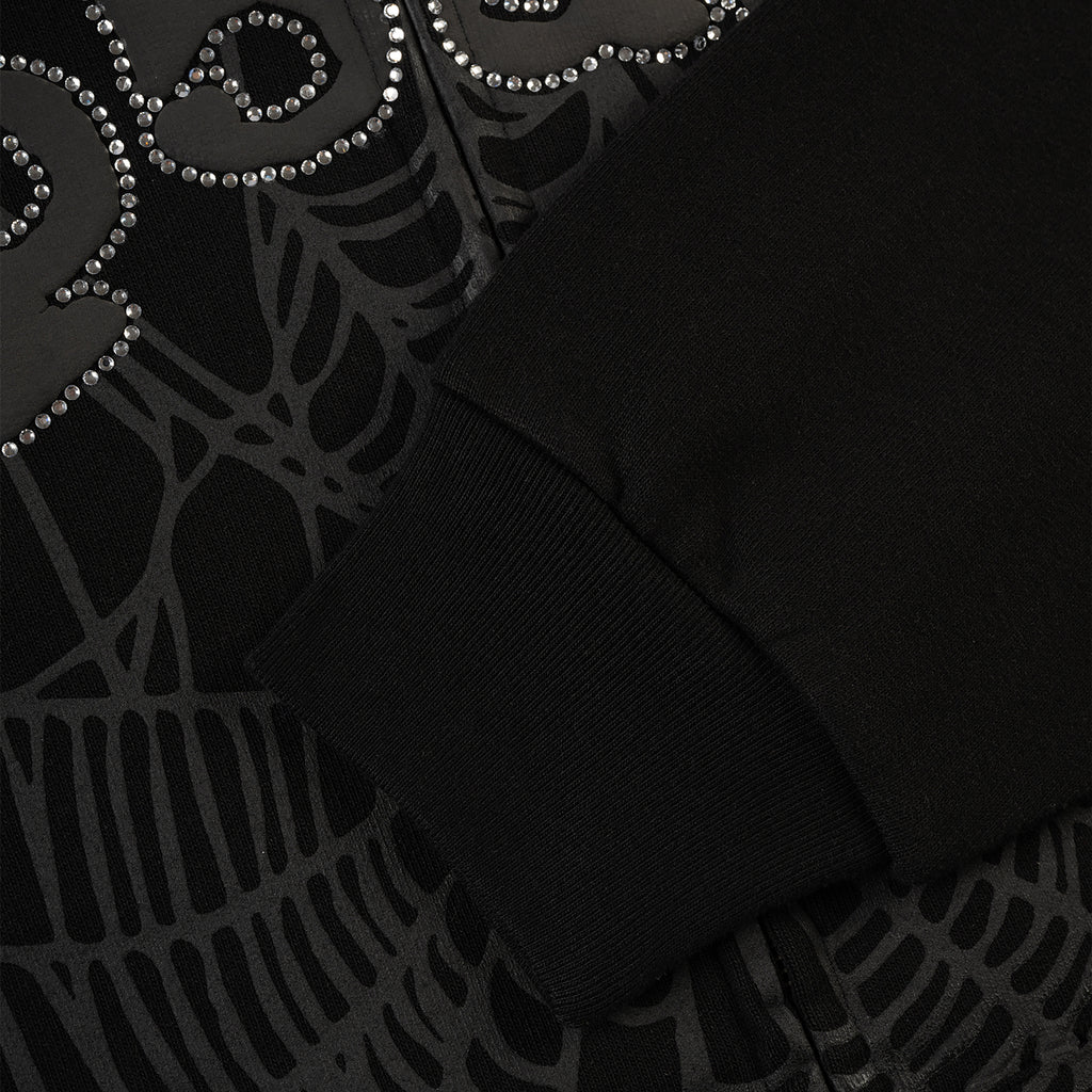 Black OG WEB V2 Rhinestone Zip Up hoodie with spiderweb design and ribbed cuff.