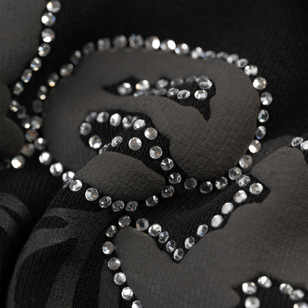 Close-up of black cotton fleece OG WEB V2 zip-up with rhinestone border detail.