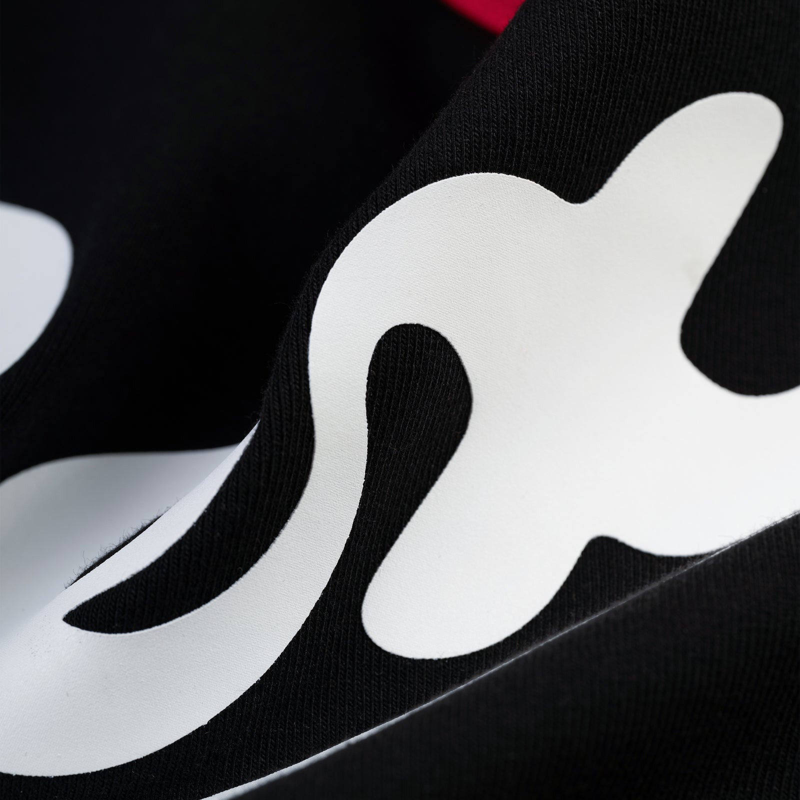 Close-up of black cotton/spandex SEX BABY TEE with white graphic print and ribbed trim.