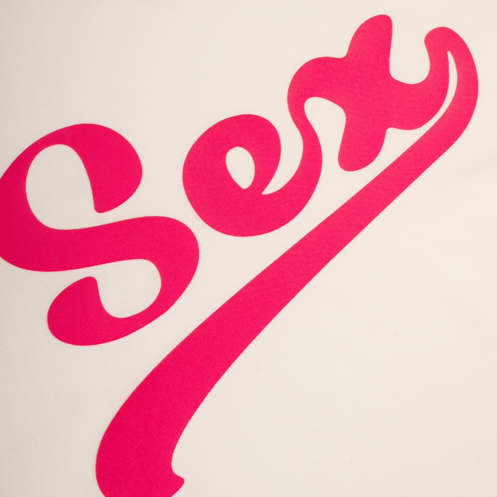 White cotton/spandex cropped tee with "Sex" in bold pink script on front.