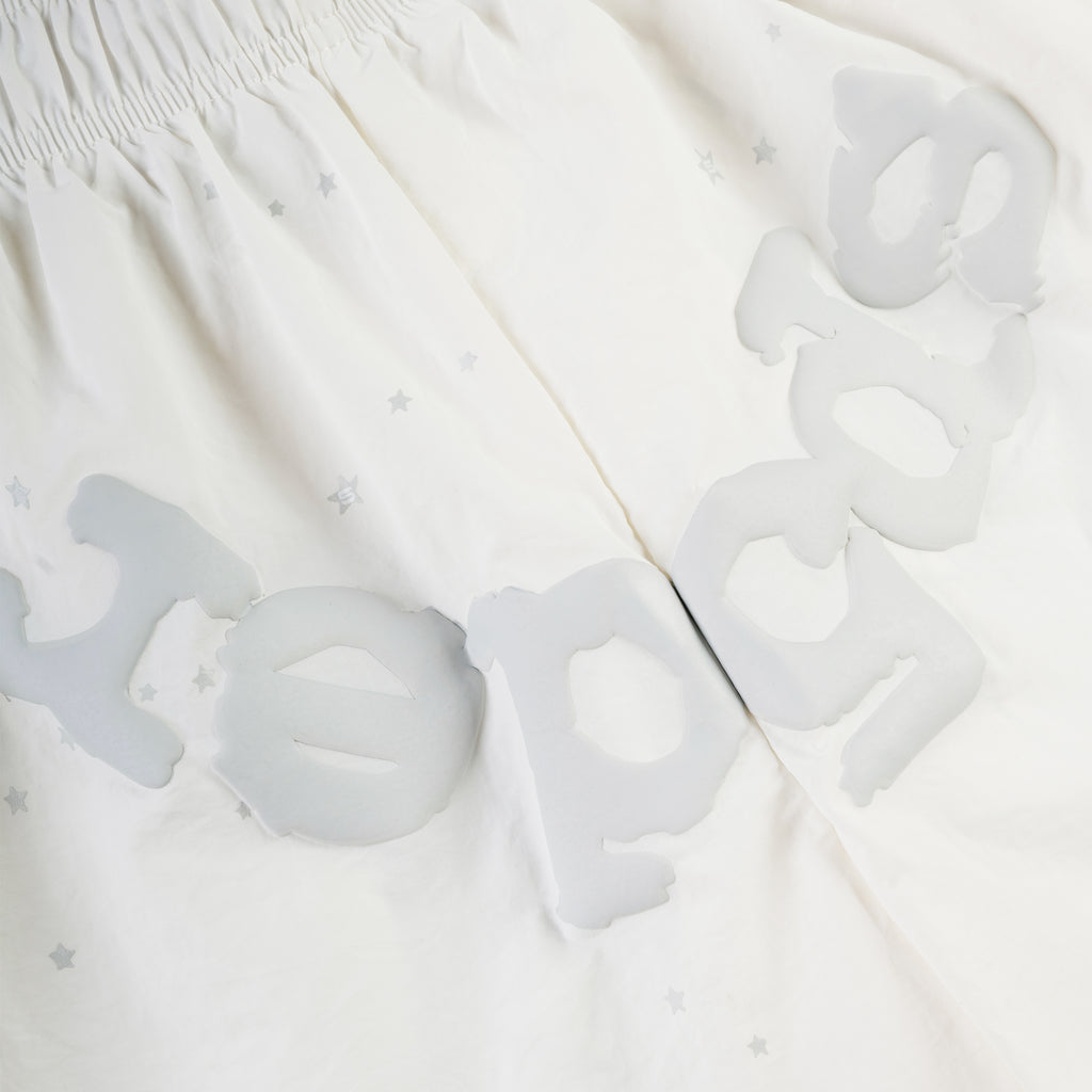 White OG WEB double layer shorts with grey SP5DER text and star print, elastic waistband.