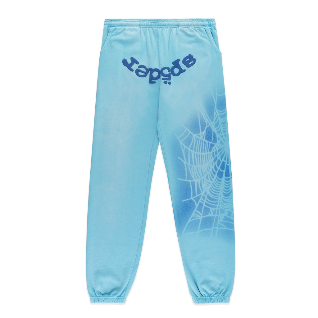 Light blue cotton fleece sweatpants with "SP5DER" text at crotch and a white spray web design on the right leg.