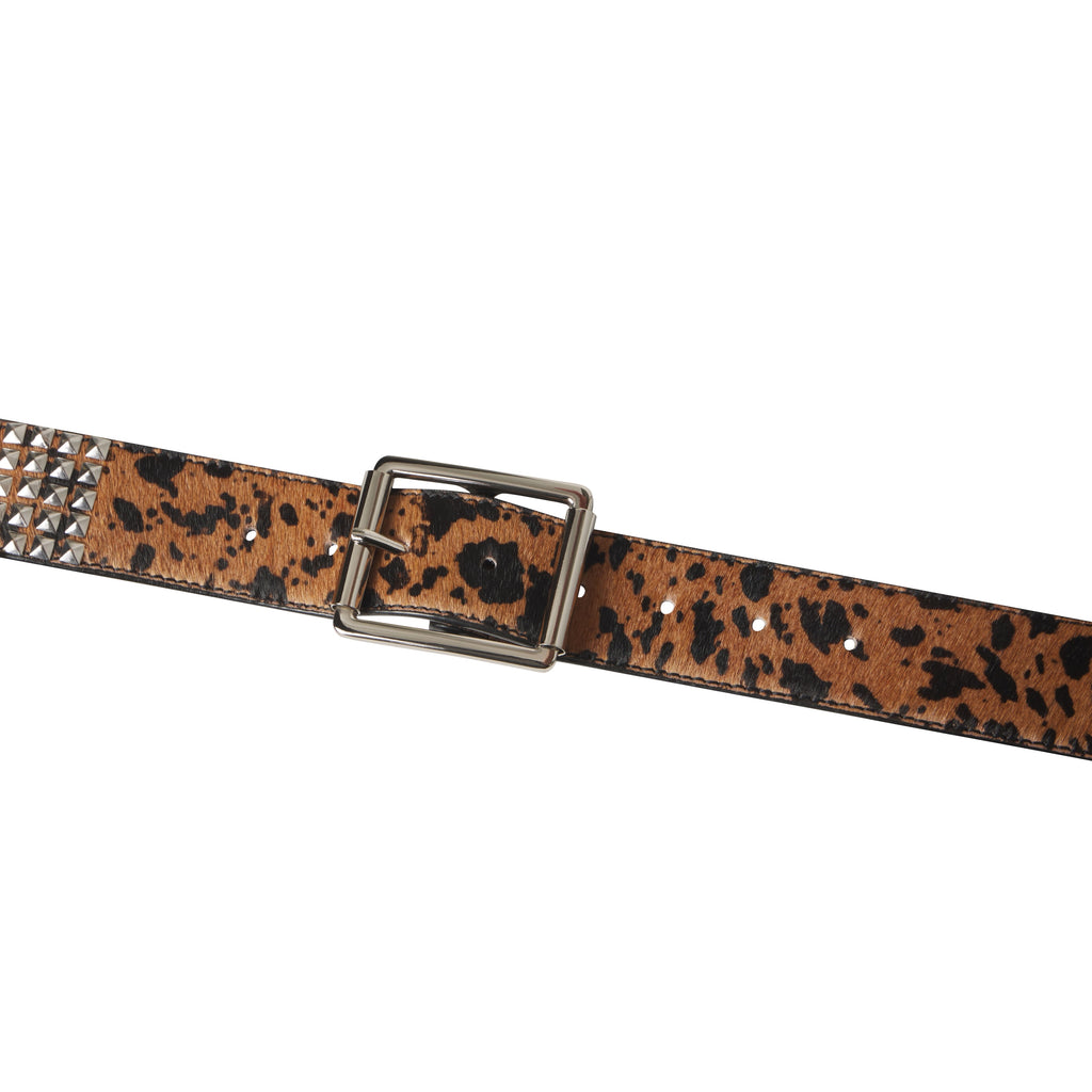 Leopard print pony hair belt with silver pyramid studs and a polished rectangular buckle on a white background.