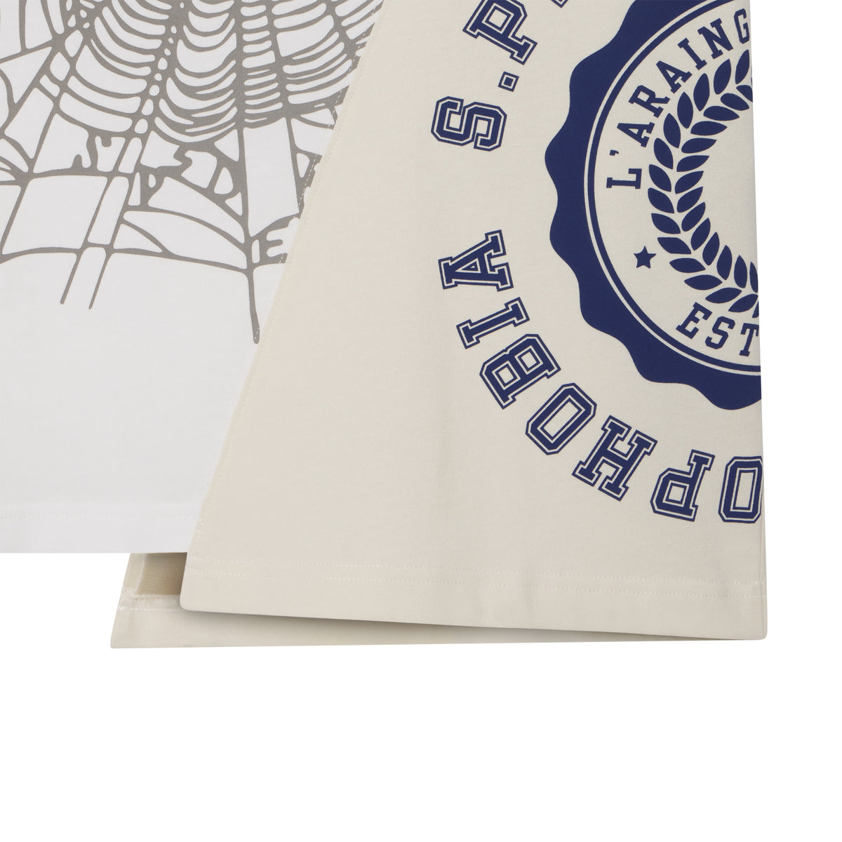 Asymmetrical cotton tee featuring color-block panels, a grey web graphic, and a blue collegiate-style circular graphic print.