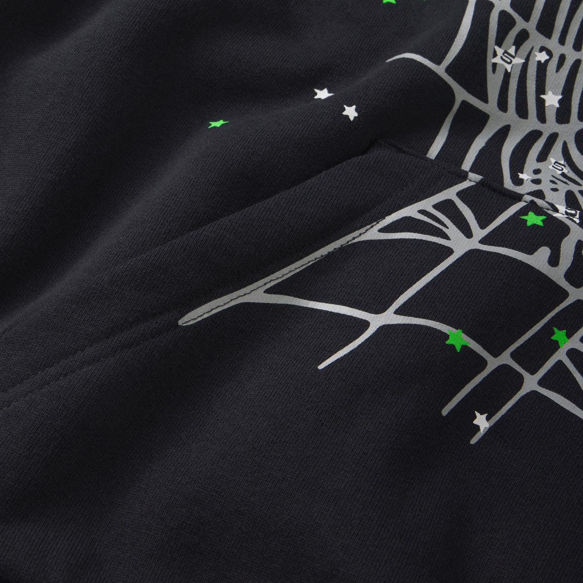 Black cotton fleece hoodie featuring a grey spider web graphic, scattered white and green star prints, and a kangaroo pocket.