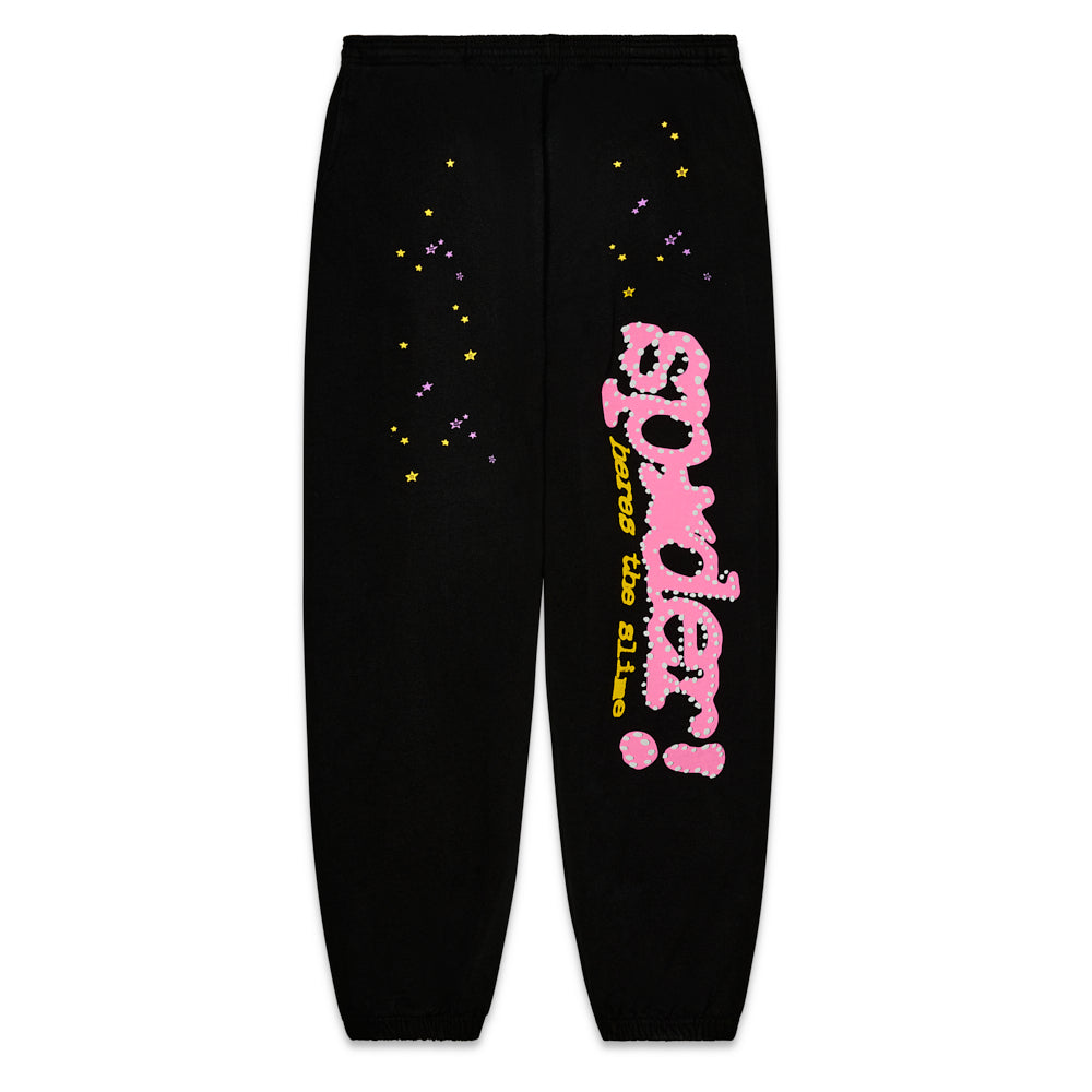 Black fleece sweatpants with pink "SP5DER" puff print, yellow "heres the slime" discharge print, and scattered yellow and purple stars.