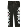 Black vintage denim with white web design and colorful rhinestone embellishments down each leg.