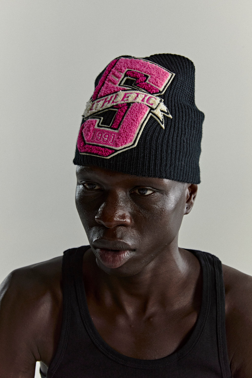 Black knit ribbed beanie with a pink '5 Athletic' chenille patch.