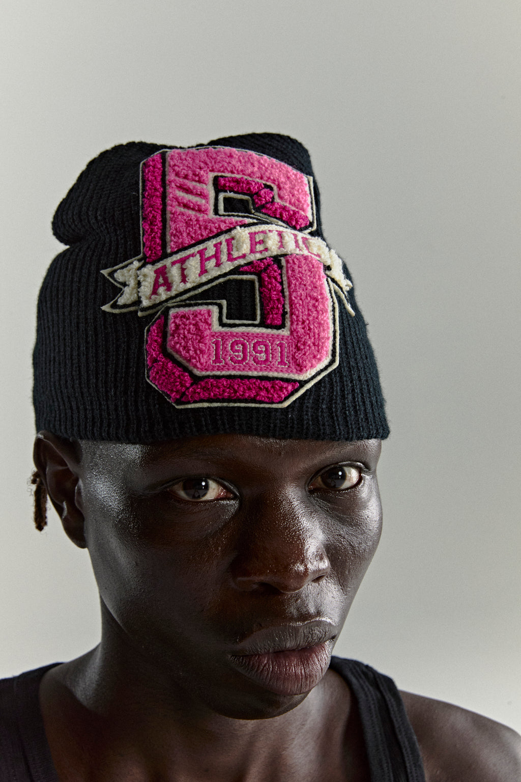 Black knit ribbed beanie with a pink chenille '5 Athletic 1991' patch.