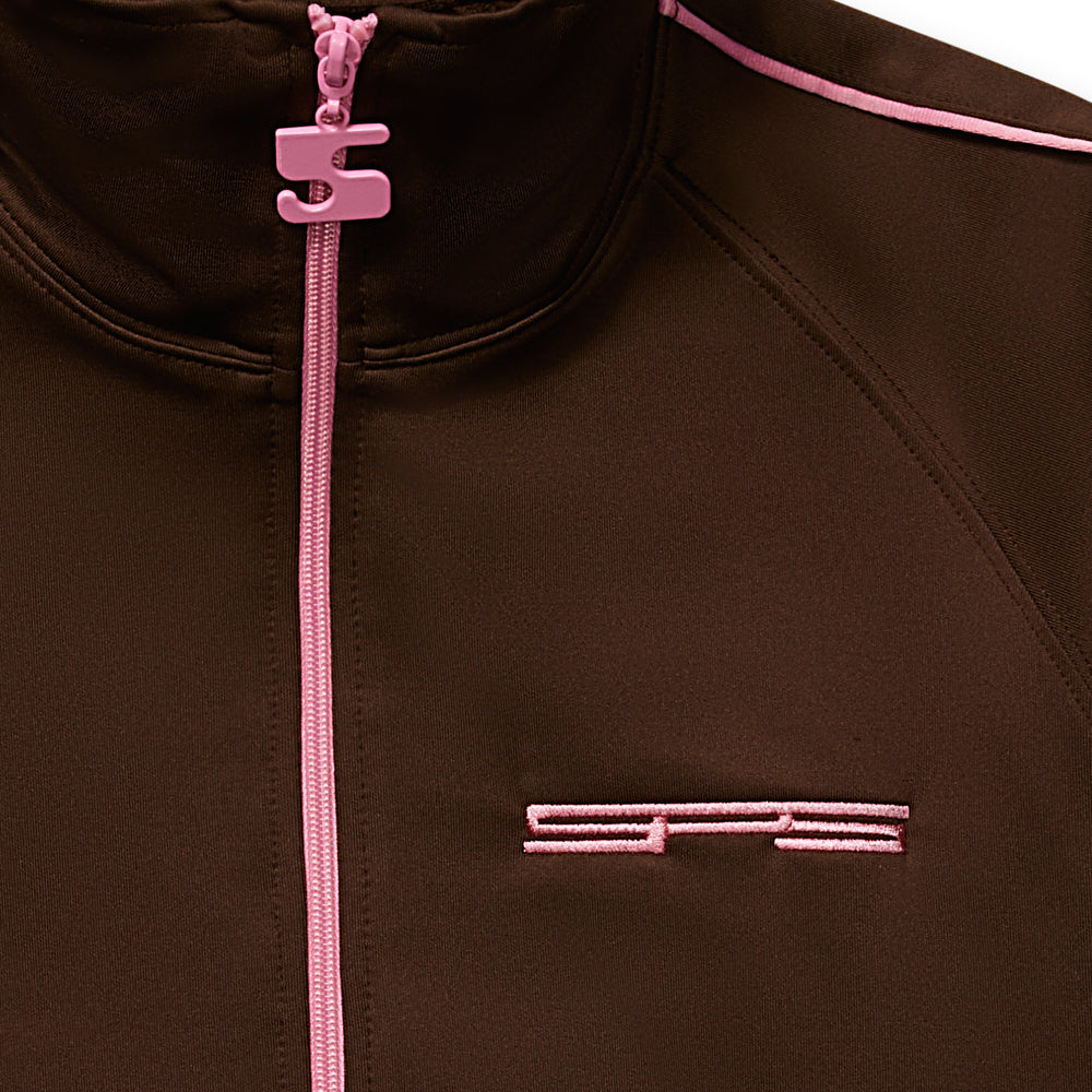 Brown poly blend track jacket with pink full zip, SP5 logo, and zipper pull charm.