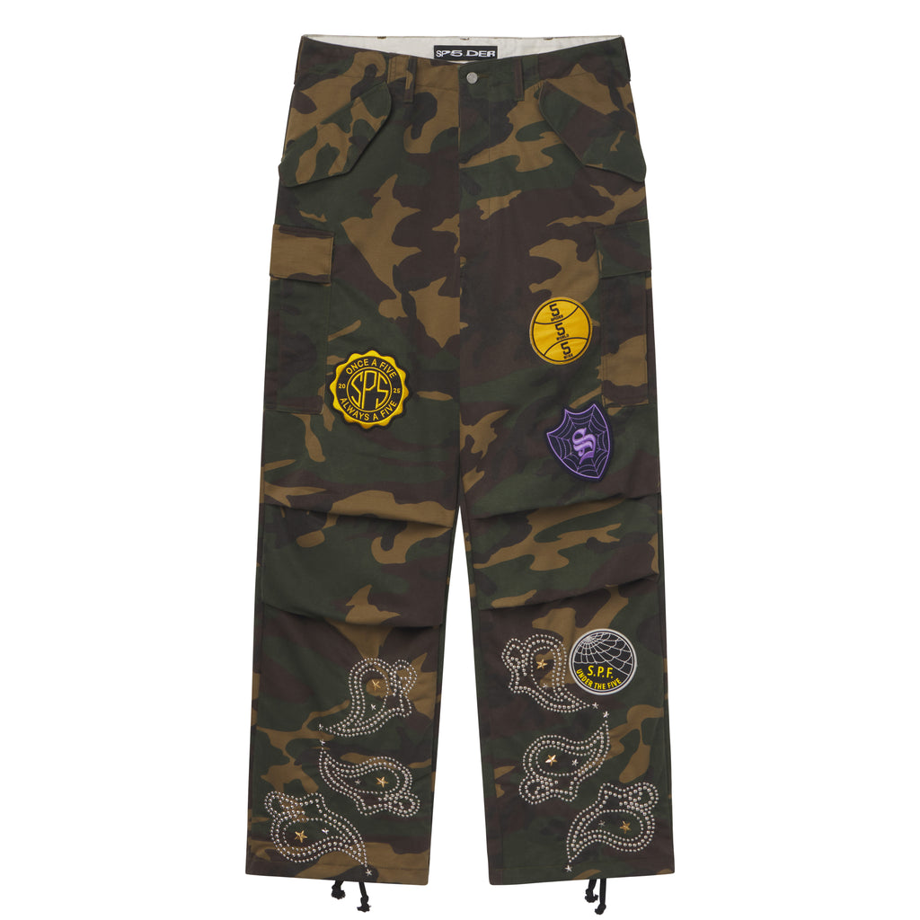 Wide-leg camo cotton cargo pants with embroidered graphic patches and studded paisley designs at the hems.