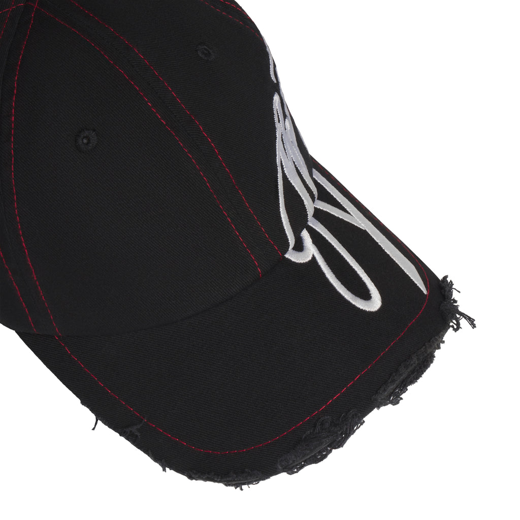 Black baseball hat with red stitching, distressed brim edges, and white cursive graphic embroidery extending to the side.
