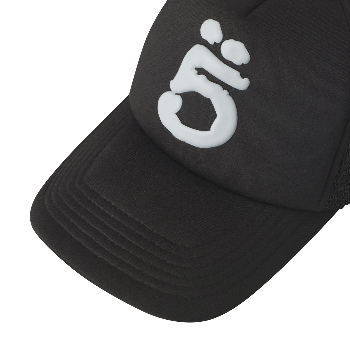 Black trucker hat with white puff print logo, curved brim, and embroidered web mesh side panels.