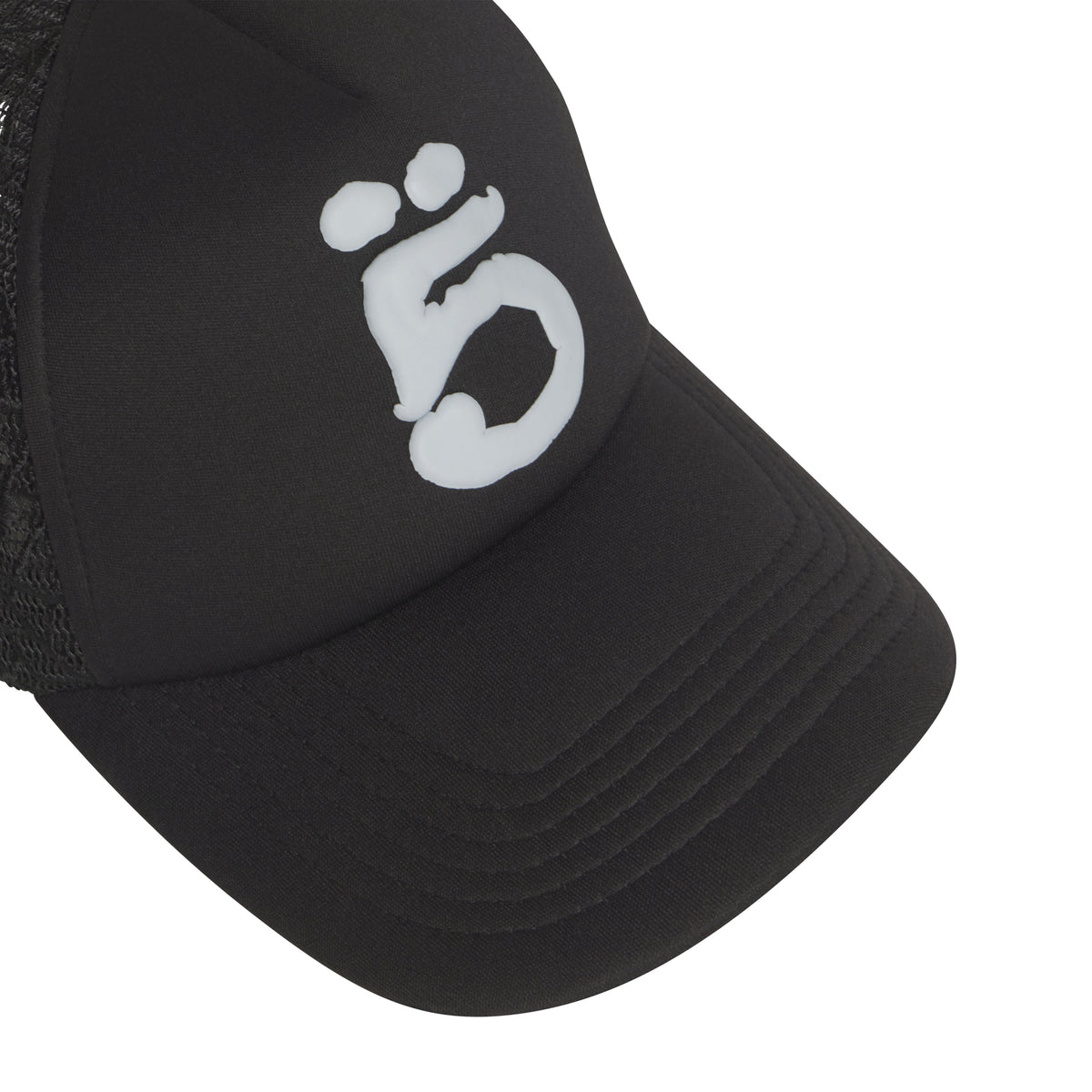 Black trucker hat with a white puff print graphic logo, curved brim, and breathable mesh side panels.