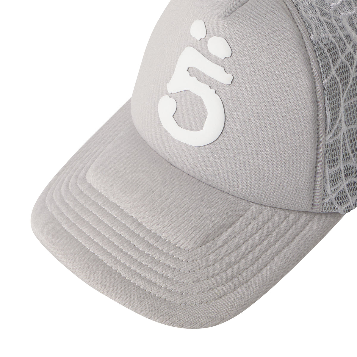 Grey trucker hat with a white puff print logo, curved brim, and detailed embroidered web mesh side panels.