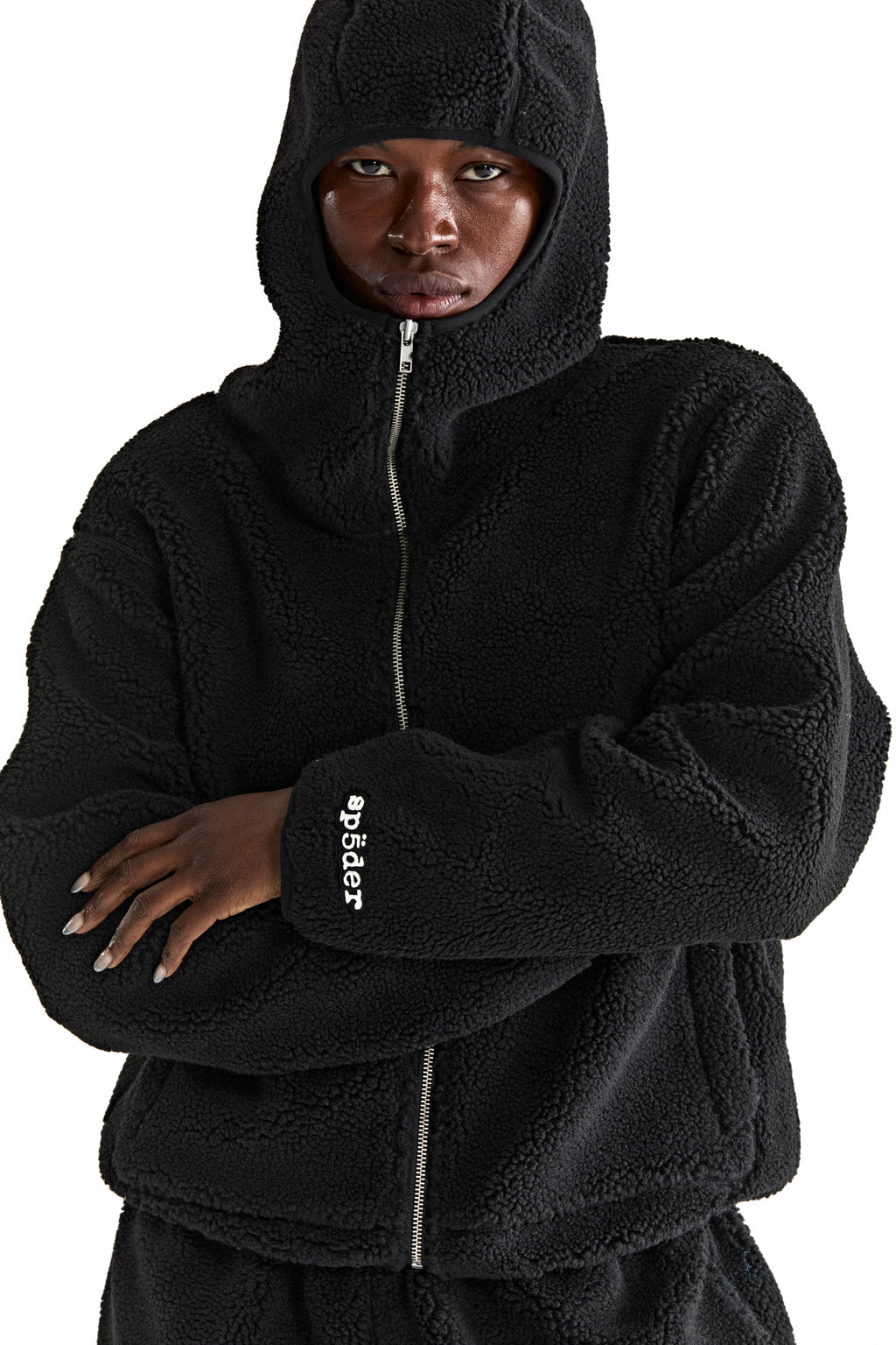 Black sherpa fleece zip-up hooded jacket with rubberized logo patch on wrist.