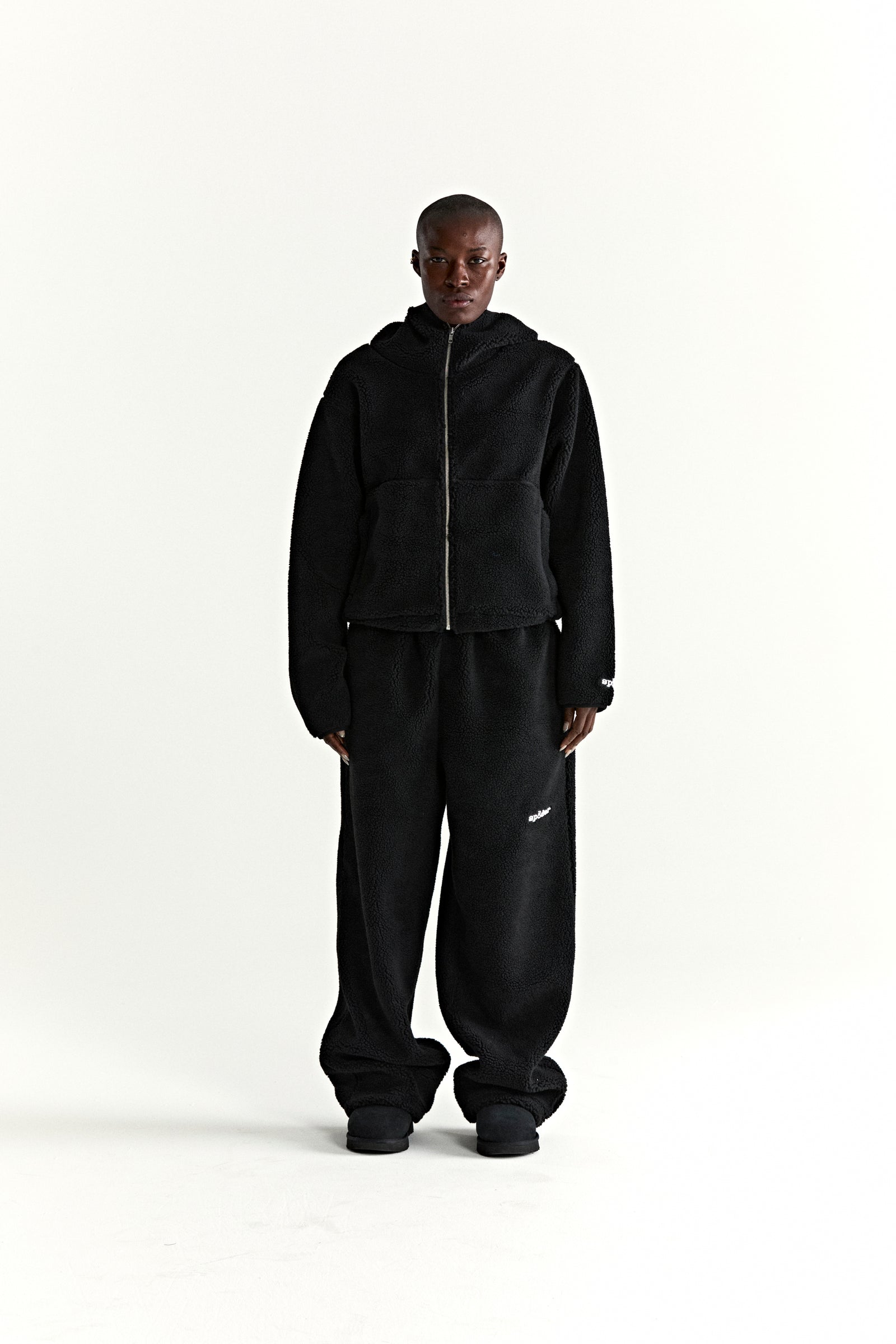 Black teddy fleece zip-up jacket with hood and matching sweatpants, worn by a model.