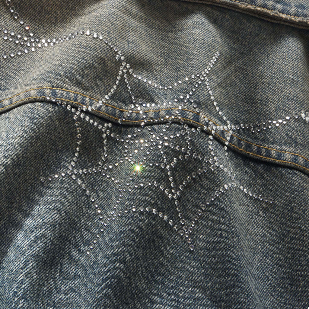 Blue denim jacket featuring a sparkling rhinestone web graphic design.