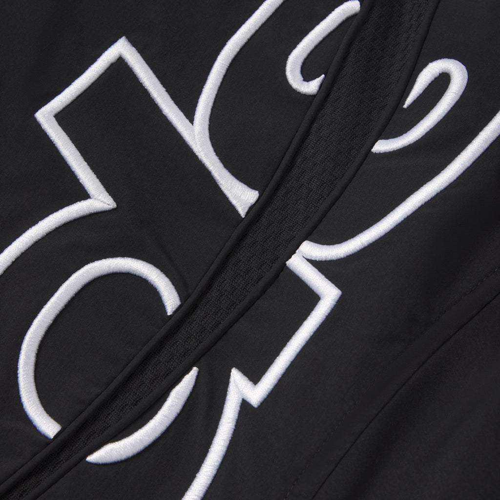 Black nylon track jacket featuring white embroidered graphic design and a full zip closure with a textured center panel.