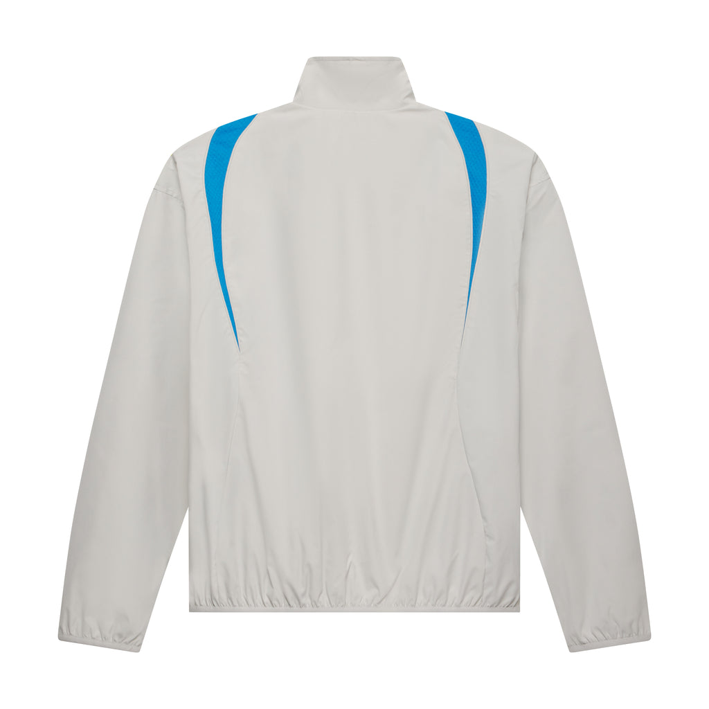 Back view of a beige nylon track jacket with a stand collar, elastic hem, and vibrant blue contrast side panels.