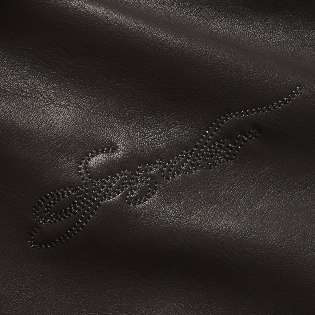 Black faux leather texture featuring tonal SP5DER graphic design embroidery.