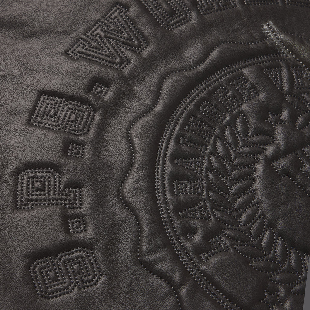 Black faux leather jacket featuring tonal SP5DER graphic design with intricate stitched detailing and embossed branding.