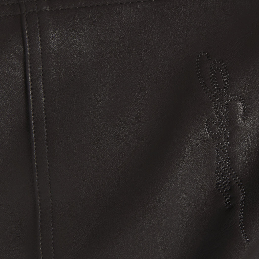 Black faux leather jacket texture featuring subtle tonal SP5DER graphic branding and detailed seam stitching.