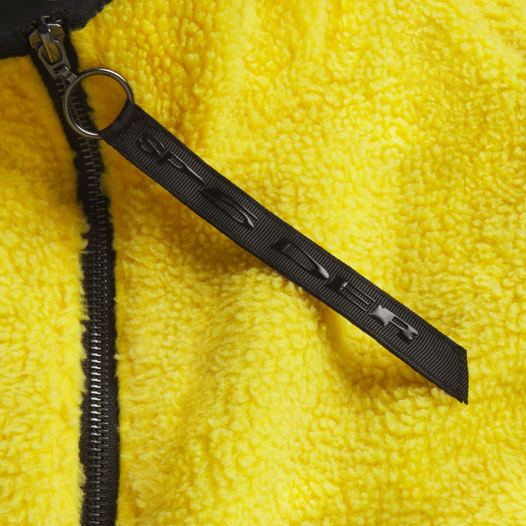 Bright yellow textured fleece jacket with a black full-length zipper and branded ring pull featuring graphic SP5DER lettering.